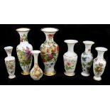 Seven Victorian floral hand painted opaque glass vases, heights ranging from 40.5cm to 24.5cm.