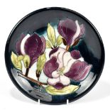 MOORCROFT; a 'Magnolia' pattern plate, impressed marks and painted initials, diameter 26cm.