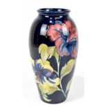 MOORCROFT; a 'Hibiscus' pattern vase, decorated with flowers against a blue ground, impressed