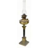 An early 20th century brass oil lamp on a Corinthian column on stepped plinth base, height 61cm.