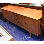 VANSON; a mid century teak sideboard, with three cupboard doors, and four drawers, on tapered