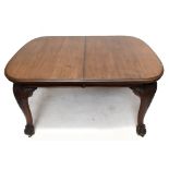 An early 20th century mahogany wind-out dining table, the top with a moulded edge and two spare