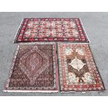 Three wall rugs, the largest decorated with an all over floral design against a beige ground, size