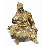 A Chinese gilt and patinated bronze seated warrior, unmarked, height 22cm.