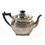 CHARLES STUART HARRIS; a late Victorian hallmarked silver teapot of oval panelled form with ebonised