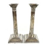 HAWKSWORTH, EYRE & CO LTD; a pair of George V Corinthian column loaded candlesticks, height 26m.