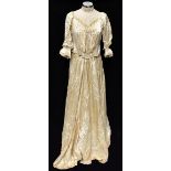 An Edwardian cream silk two piece skirt and blouse, comprising a full length satin skirt with tiered