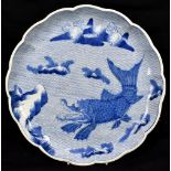 A 19th century Japanese Arita blue and white dish with shaped rim and painted with a mythical