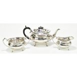 HAMMOND, CREAKE & CO; a George V hallmarked silver three piece tea service with panelled decoration,