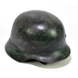 A German military helmet with traces of painting and decal.