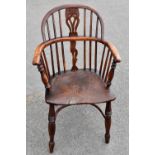 An 18th century elm seated low back Windsor elbow chair with yew wood back and crinoline stretcher.