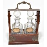 A mahogany and silver plated tantalus, housing two hobnail cut glass decanters with silver plated