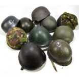 An assortment of nine British and other military helmets, various styles and dates.