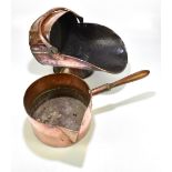 A copper helmet form coal scuttle, and a copper pan with turned wooden handle, width of pan 56cm (