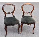 A pair of Victorian walnut balloon back dining chairs