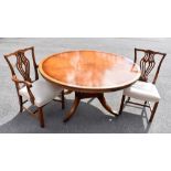 A reproduction mahogany dining table, the circular top on four columns terminating on four sabre