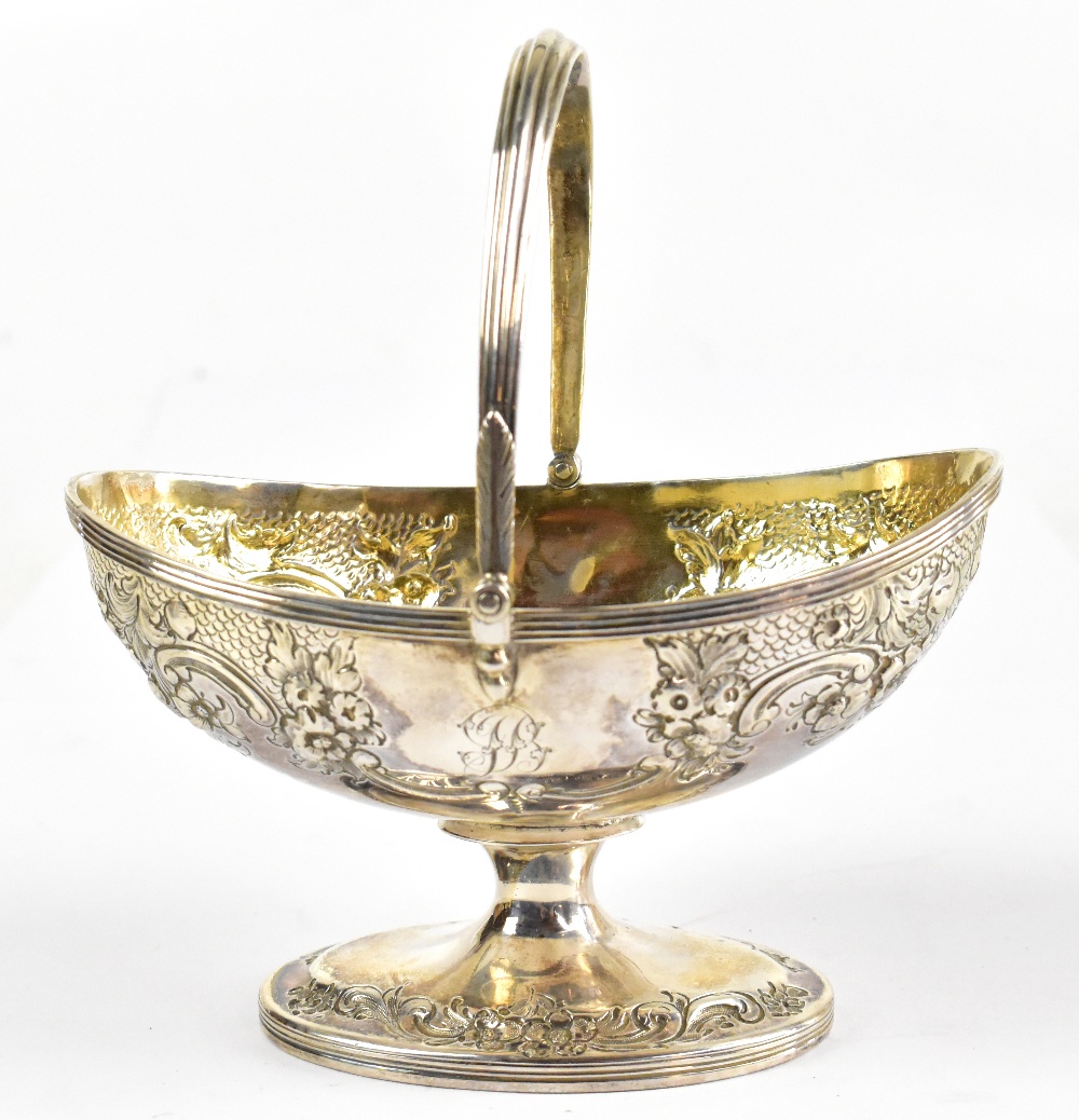 JOHN EMES; a George III hallmarked silver gilt oval basket with swing handle and floral