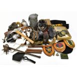 An assortment of WWII and later military ephemera, including gas masks, a circular metal tin,