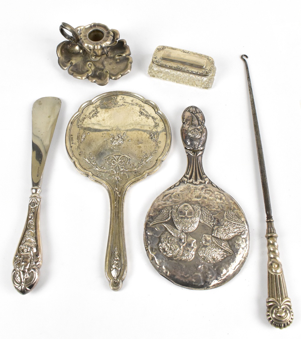 An assortment of silver items including two hallmarked silver hand mirrors, one decorated with