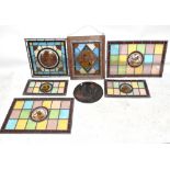 A collection of seven Victorian and later stained glass panels, including a pair of rectangular