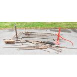 Two vintage cast iron carriage jacks, a WWII stretcher, various other metal tools, etc.