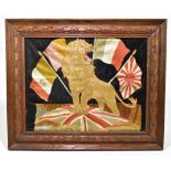 A WWI Flag of Nations embroidered panel depicting a roaring lion and five Allied flags in carved