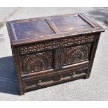 A 17th century oak coffer with panelled top above carved panelled front, with floral decoration