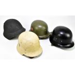 Four German helmets, including a WWII Stahlhelm type helmet with two insignia (4).