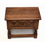 A carved oak sewing stool with hinged lid, on block feet, height 38cm, width 48cm, depth 30cm.