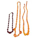 A strand of amber coloured beads, largest approximately 2.5cm, length 65cm, a strand of cherry amber