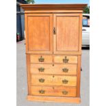 An old pine linen press with moulded cornice above a pair of panelled doors enclosing single fixed