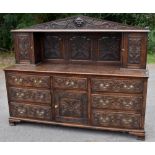 A 19th century carved oak Flemish style sideboard, the back section with carved lion mask, flanked