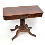 An early 19th century mahogany fold over swivel-top tea table with carved detail to the front, on
