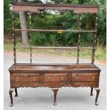 An 18th century oak Shropshire type dresser with open plate rack back having carved and pierced