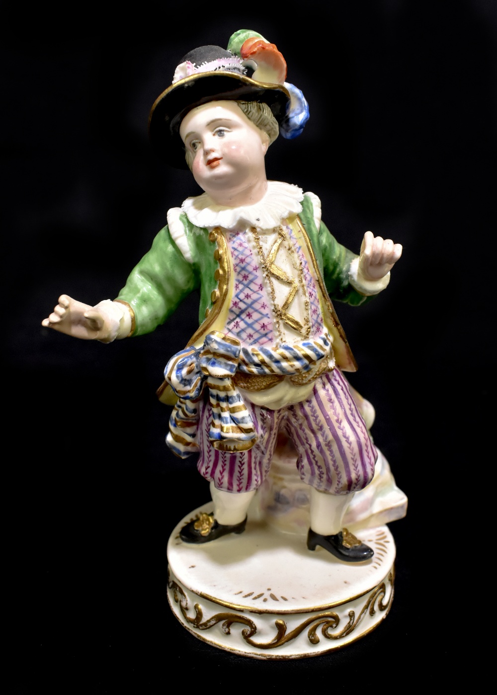 MEISSEN; an early 20th century figure of a portly young gentleman wearing elaborate clothing,