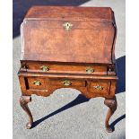 A George III style burr walnut bureau of shaped form, with crossbanded detail above the fall front