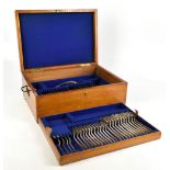 An early 20th century oak cased table part canteen of silver plated cutlery.