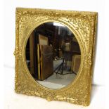 A 19th century gilt framed wall mirror with oval plate and elaborate frame, 102 x 88cm.