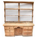 An old pine dresser with hanging plate rack back, the back section with three fixed shelves above