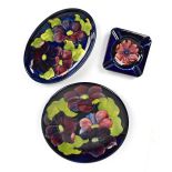 MOORCROFT; a plate and oval dish decorated in the 'Clematis' pattern, and an ash tray in the '