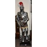 A modern reproduction 16th century style suit of armour raised on stepped square sectioned base,