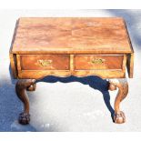 A 1950s reproduction walnut drop-leaf coffee table with two drawers on carved cabriole supports,