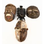 Four tribal masks, including a Nigerian mask with coloured detail, length 43cm, a Gabon mask, a