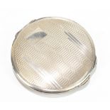 A hallmarked silver compact of circular form with engine turned decoration in the Art Deco style,