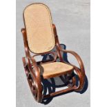 A Thonet style steamed wood rocking chair, with caned back and seat.