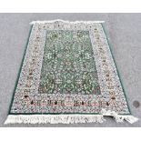 A Persian wool rug, worked with an allover floral design against a green ground, 168 x 109cm.