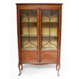 An Edwardian line inlaid mahogany display cabinet, the pair of glazed door enclosing two fixed