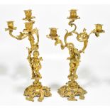 A pair of late 19th century gilt metal figural candelabra, representing cherubs supporting three