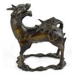 A Chinese bronze incense burner modelled as a kylin with head turned backwards over its hinged