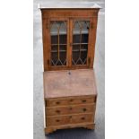 An 18th century and later walnut bureau bookcase, the glazed top above a feather banded fall front